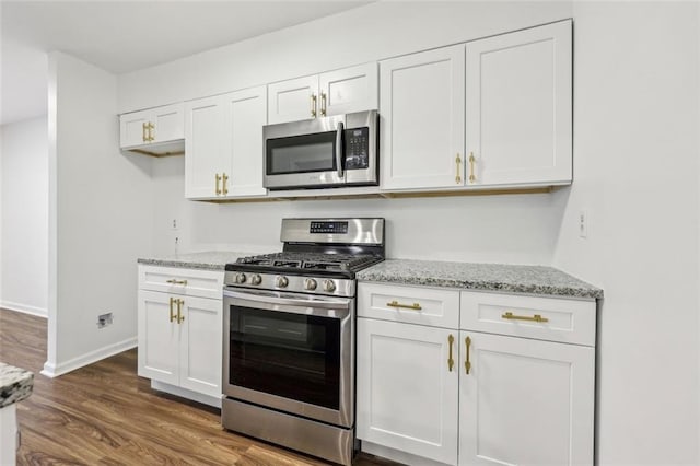 kitchen featuring stainless steel appliances, light stone countertops, dark hardwood / wood-style floors, and white cabinets