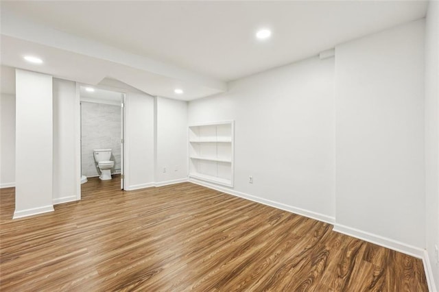 basement featuring wood-type flooring and built in shelves