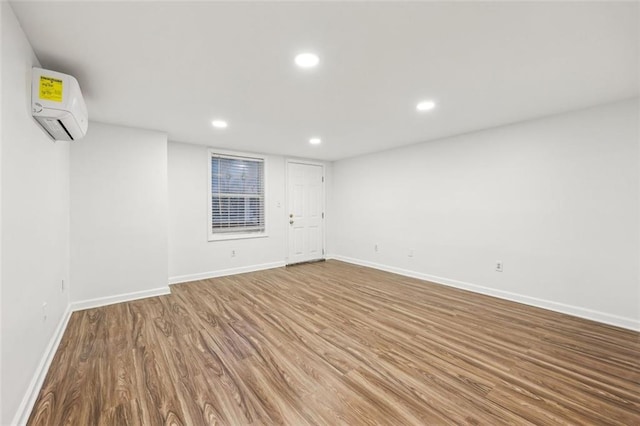 spare room with hardwood / wood-style flooring and a wall mounted AC