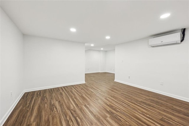 basement with dark hardwood / wood-style floors and a wall mounted air conditioner