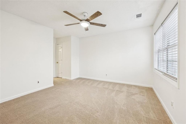 spare room featuring ceiling fan and light carpet