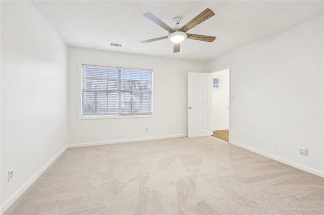 empty room with ceiling fan and light colored carpet