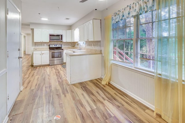 333 Lynne Cir, Alpharetta, GA 30009 - kitchen featuring appliances with stainless steel finishes, a sink, light wood-style flooring, decorative backsplash, and white cabinets