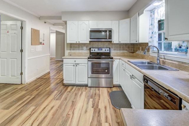 333 Lynne Cir, Alpharetta, GA 30009 - kitchen with appliances with stainless steel finishes, a sink, white cabinetry, light wood-style flooring, and crown molding