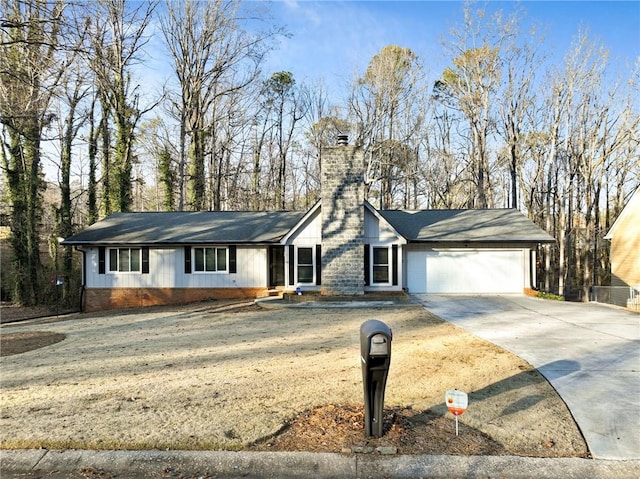 ranch-style home featuring a garage, a chimney, concrete driveway, and a front yard