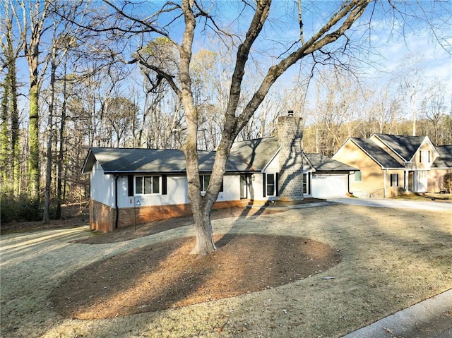 ranch-style house featuring driveway and a chimney