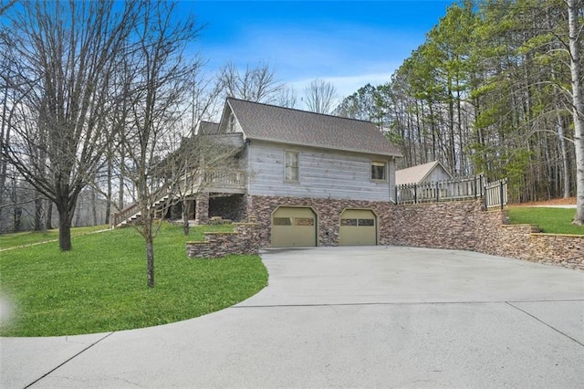 view of home's exterior featuring an attached garage, fence, concrete driveway, stairway, and a lawn