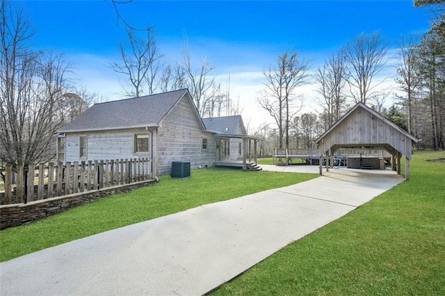 view of property exterior featuring a shingled roof, a yard, an outdoor structure, central air condition unit, and a carport