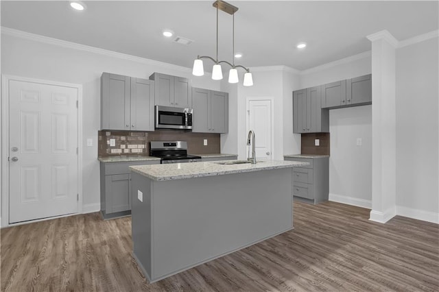 kitchen featuring stainless steel appliances, sink, gray cabinets, and a kitchen island with sink