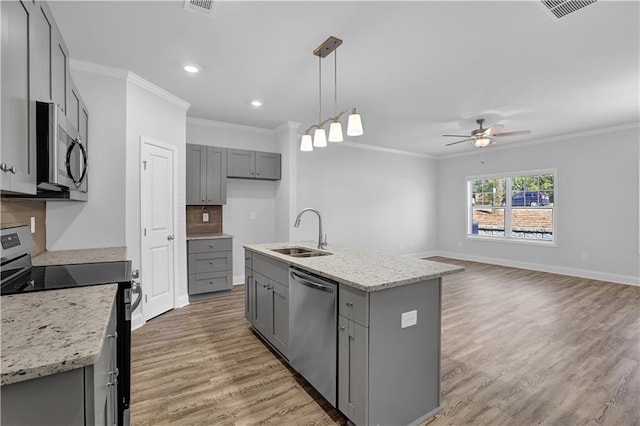 kitchen with sink, gray cabinetry, decorative light fixtures, appliances with stainless steel finishes, and an island with sink