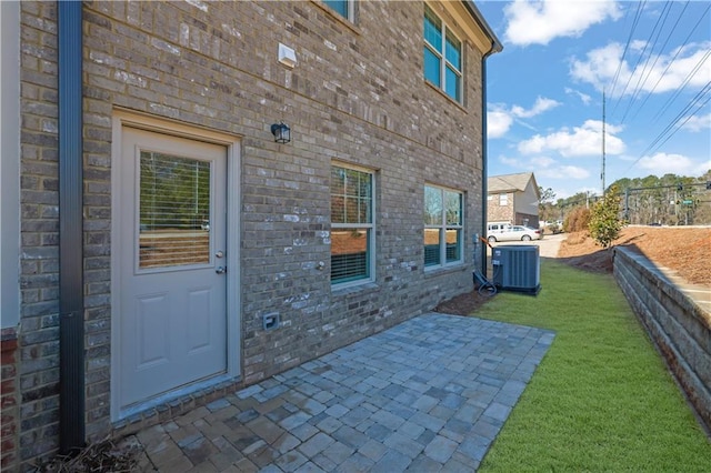 entrance to property featuring central AC, a yard, and a patio area