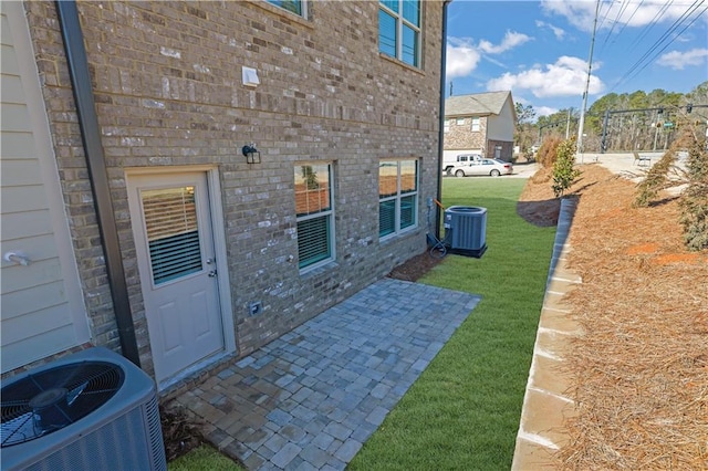 exterior space with cooling unit, a yard, and a patio