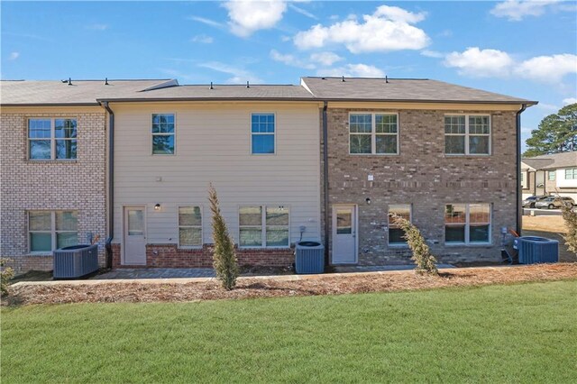 back of property featuring central AC unit and a yard