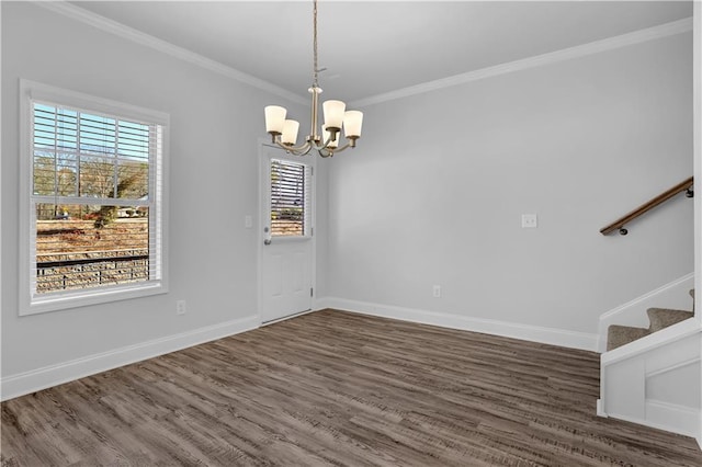 empty room featuring crown molding, dark hardwood / wood-style floors, and an inviting chandelier