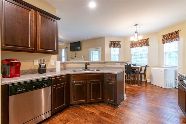 12275 Styron Dr, Hampton, GA 30228 - kitchen featuring stainless steel dishwasher, a sink, dark wood-type flooring, light countertops, and a peninsula