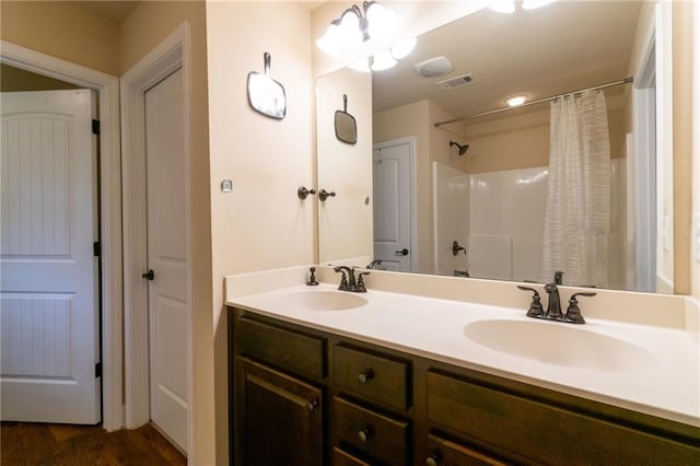 12275 Styron Dr, Hampton, GA 30228 - bathroom featuring double vanity, a shower with curtain, and wood finished floors
