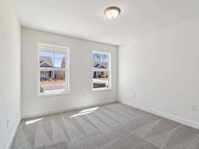 carpeted empty room with baseboards