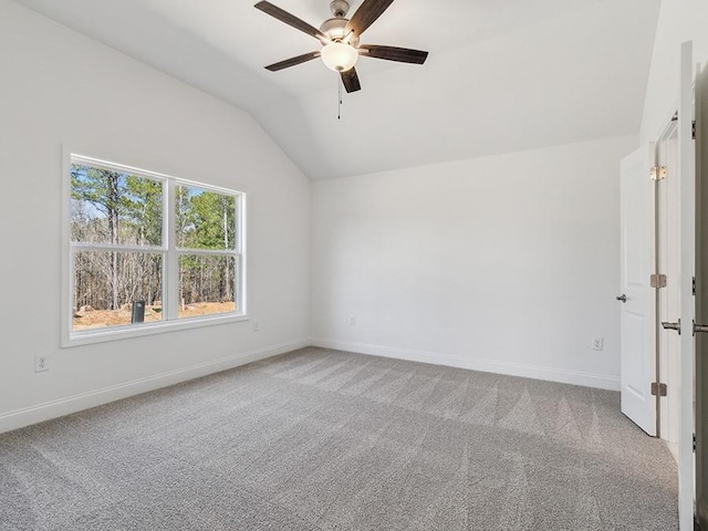 unfurnished room featuring baseboards, a ceiling fan, lofted ceiling, and carpet floors