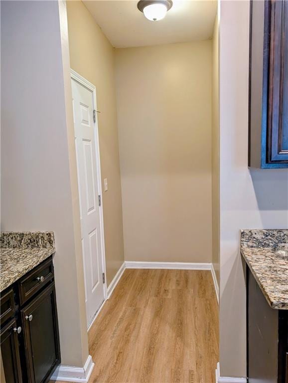 hallway with light wood-style floors and baseboards