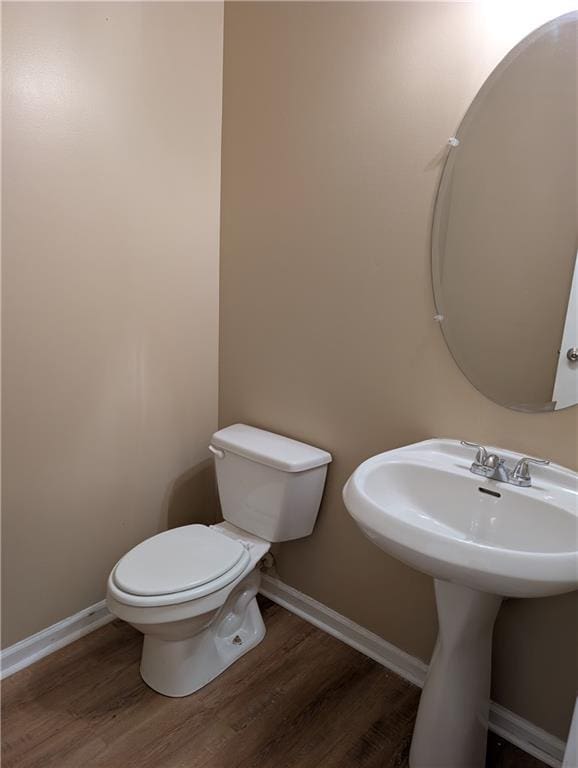 bathroom featuring wood finished floors, toilet, and baseboards
