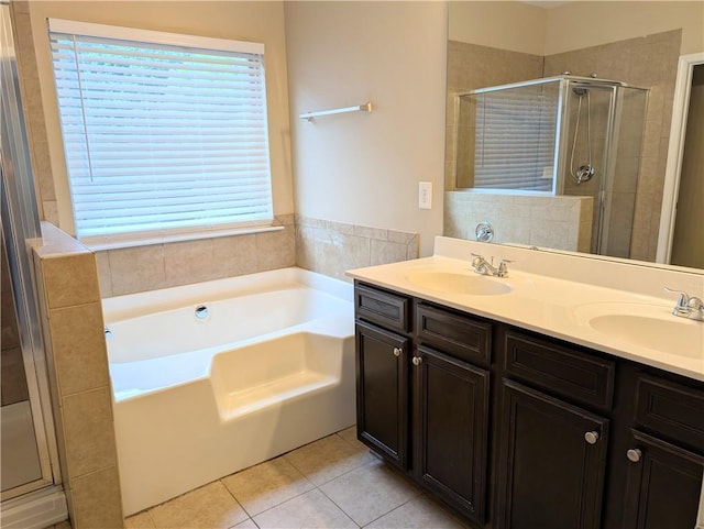 bathroom featuring a stall shower, tile patterned flooring, a bath, and double vanity