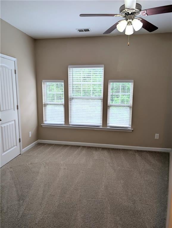 spare room with baseboards, carpet floors, and ceiling fan