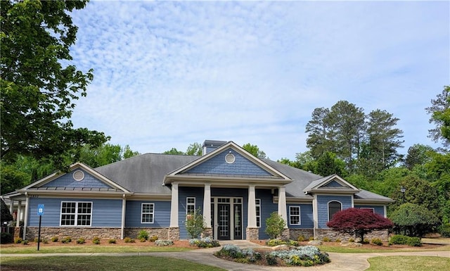 view of front facade featuring stone siding and a front lawn