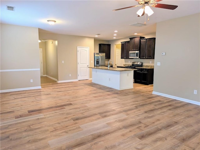 kitchen featuring stainless steel appliances, open floor plan, a ceiling fan, a sink, and recessed lighting