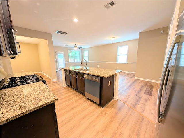 kitchen with dishwasher, a sink, light wood finished floors, dark brown cabinets, and recessed lighting