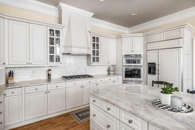 803 Night Fire Dr, Dawsonville, GA 30534 - kitchen with crown molding, decorative backsplash, stainless steel appliances, premium range hood, and light stone countertops