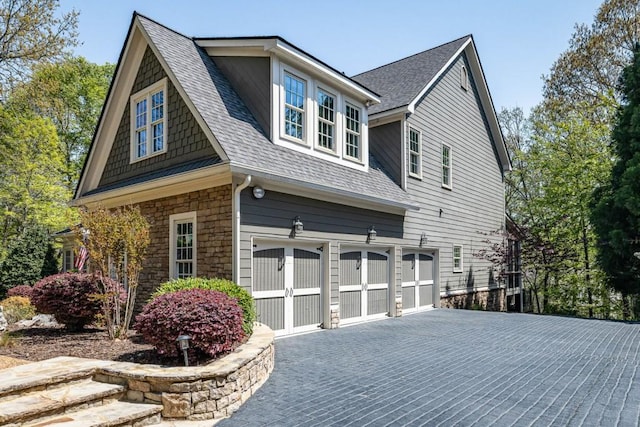 803 Night Fire Dr, Dawsonville, GA 30534 - view of side of home featuring an attached garage, a shingled roof, stone siding, and aphalt driveway
