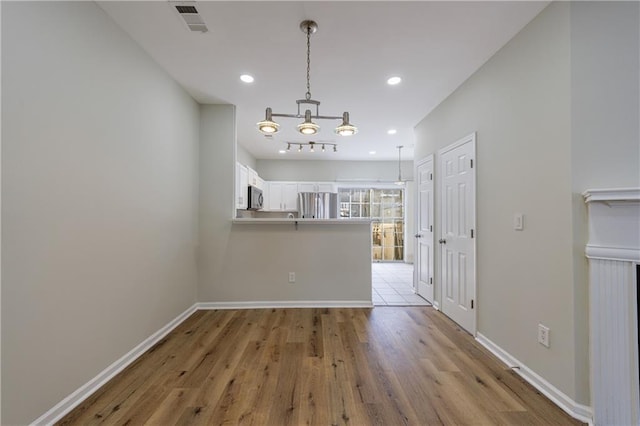 interior space with light wood finished floors, visible vents, baseboards, and recessed lighting