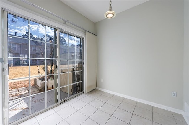 tiled empty room featuring baseboards