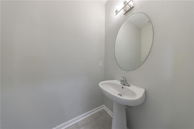 bathroom with baseboards and tile patterned floors