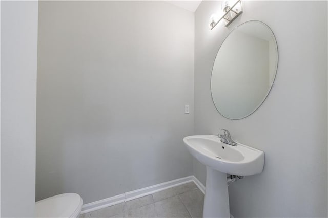 bathroom with toilet, baseboards, and tile patterned floors