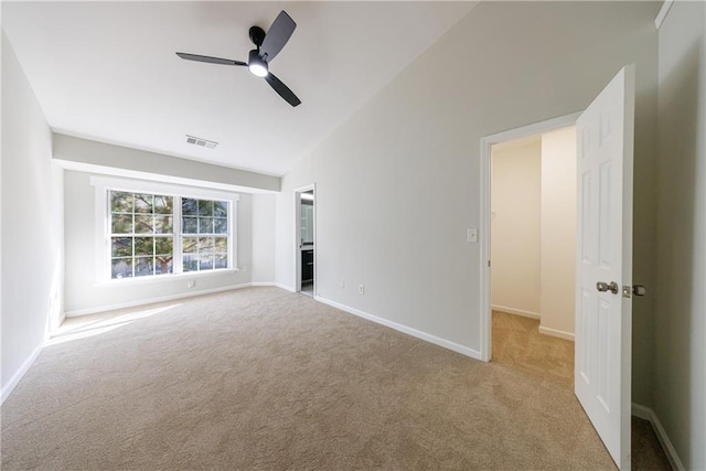 unfurnished room with visible vents, carpet flooring, vaulted ceiling, ceiling fan, and baseboards