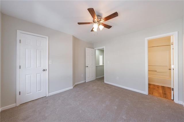 unfurnished bedroom with a ceiling fan, carpet, baseboards, and ensuite bathroom