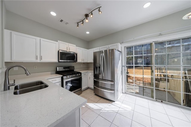 kitchen featuring stainless steel appliances, a sink, white cabinetry, visible vents, and light stone countertops