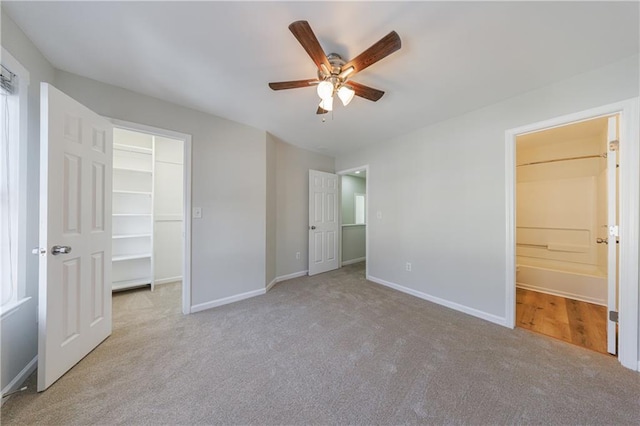 unfurnished bedroom featuring a spacious closet, carpet flooring, and baseboards