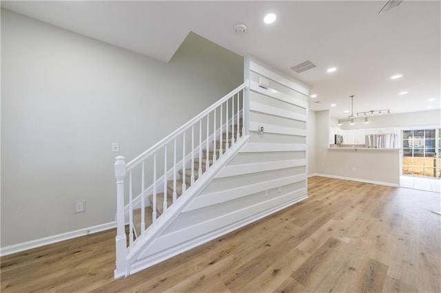 staircase with recessed lighting, visible vents, baseboards, and wood finished floors