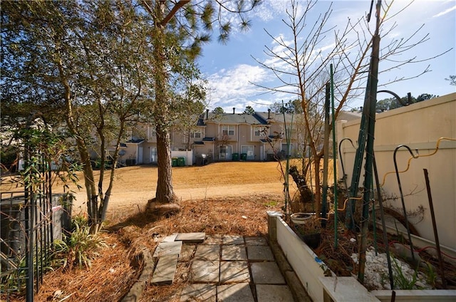 view of yard with cooling unit, a garden, and fence