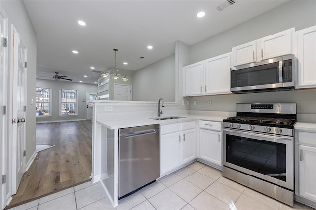 kitchen featuring appliances with stainless steel finishes, a sink, visible vents, and white cabinets