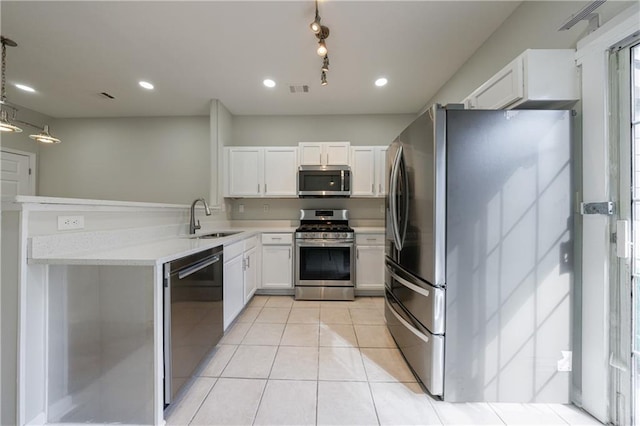 kitchen featuring light tile patterned floors, a sink, white cabinetry, light countertops, and appliances with stainless steel finishes