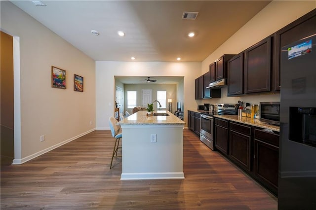 458 Bishop Ln, Woodstock, GA 30188 - kitchen with stainless steel appliances, a sink, a kitchen breakfast bar, light stone counters, and dark wood-style floors