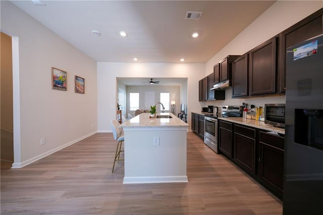 458 Bishop Ln, Woodstock, GA 30188 - kitchen featuring stainless steel appliances, a kitchen bar, light stone countertops, a kitchen island with sink, and a sink