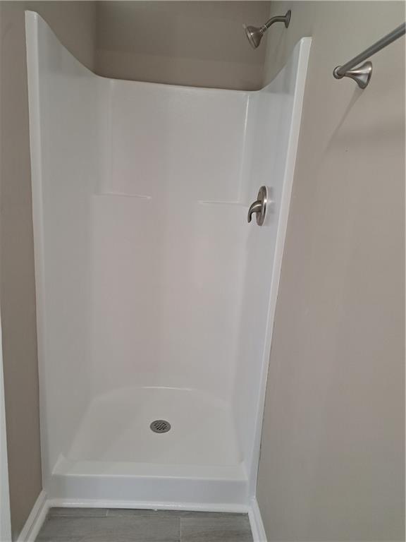bathroom with baseboards and walk in shower