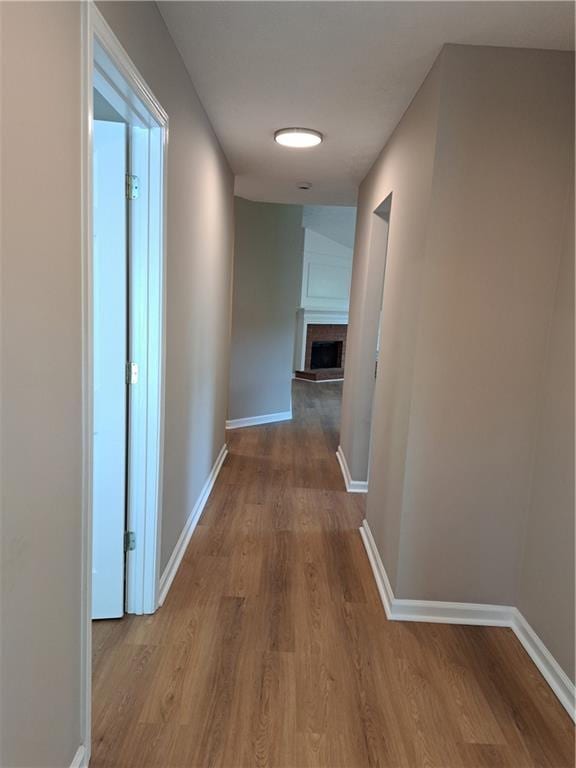 corridor with baseboards and wood finished floors