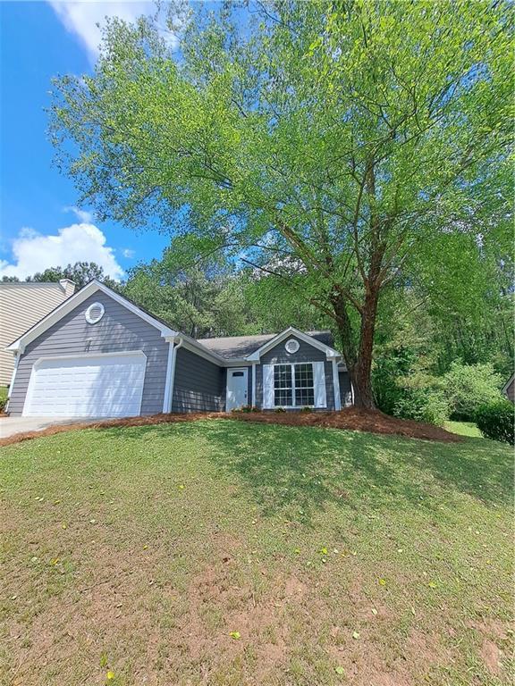 ranch-style house with driveway, a front yard, and a garage