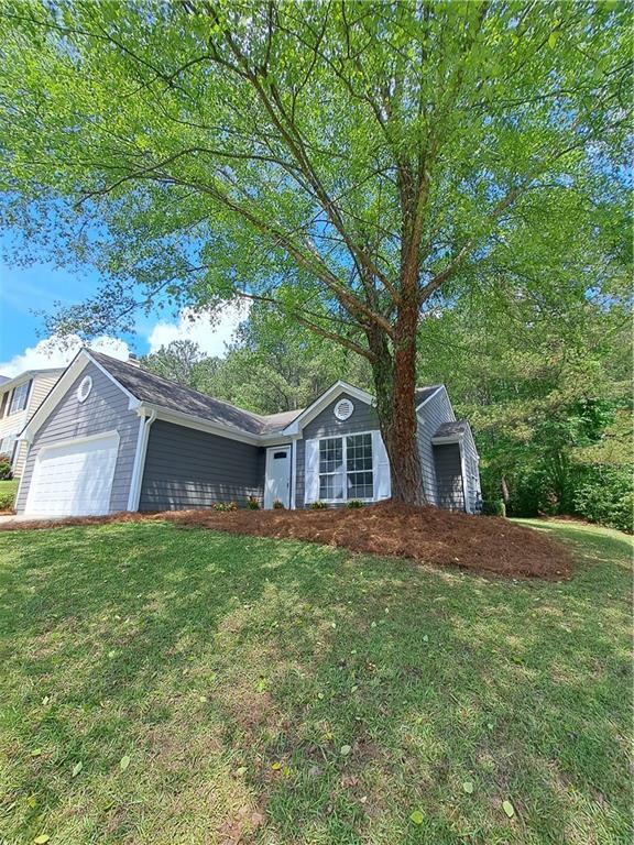 ranch-style home with an attached garage and a front lawn