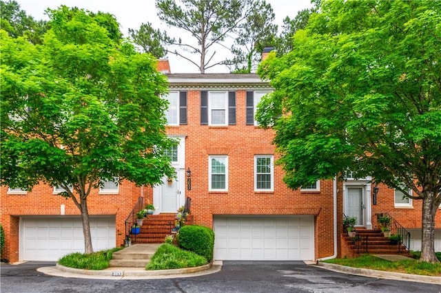 3833 Savannah Sq E, Atlanta, GA 30340 - view of front of property featuring an attached garage, driveway, brick siding, and a chimney
